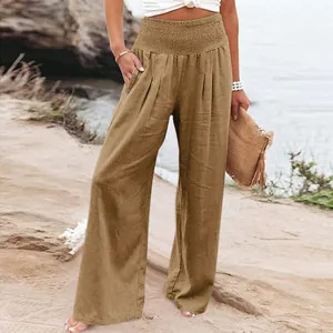 Detail of brown cotton linen wide-leg pants with smocked high waist and button pocket