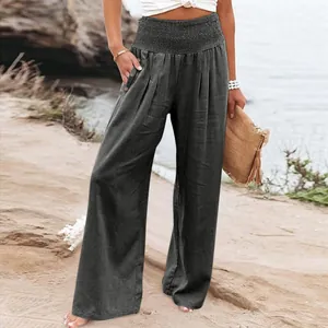 Detail view of charcoal grey linen wide-leg pants with smocked waist and button pocket