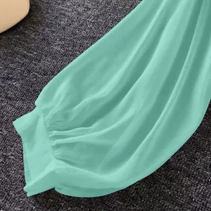 Close-up of mint green chiffon sleeve with breathable pleated texture.