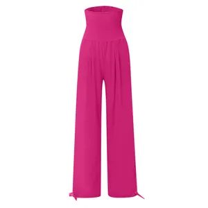 Dettaglio dei pantaloni a gamba larga magenta a vita alta arricciata con lacci sugli orli.