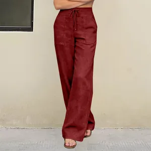 Detailed view of burgundy high-waisted wide-leg trousers with drawstring and pockets