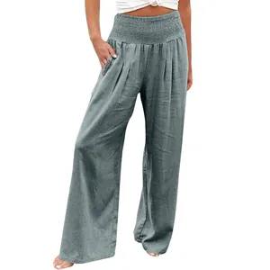 Close-up of women's grey wide-leg trousers featuring a smocked high waist and button pockets