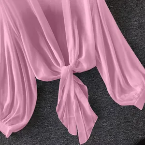 Macro detail of front tie-knot on a pink breathable chiffon sun protection shirt.