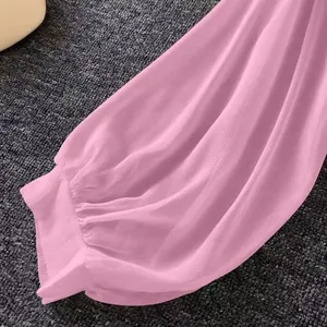 Close-up detail of light pink chiffon sun protection shirt sleeve with ruffled cuff