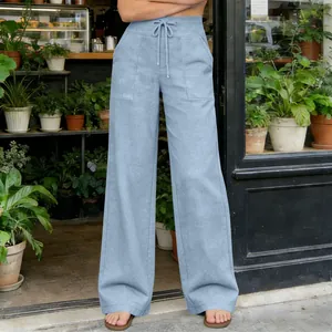 Close-up detail of light blue high-waisted wide-leg trousers with drawstring and pockets.