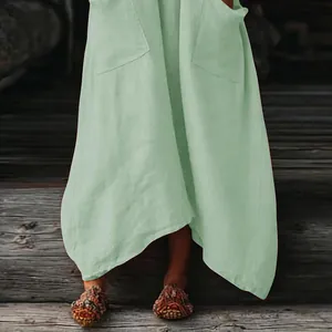 Detalle del vestido maxi bohemio verde menta con bolsillos y dobladillo asimétrico