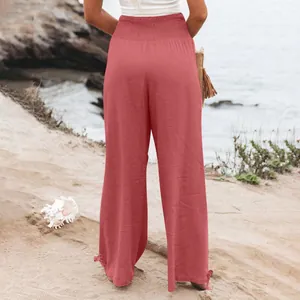Vista posteriore pantaloni larghi a vita alta donna con fiocco sull'orlo sulla spiaggia