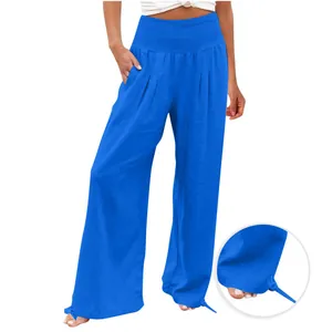 Dettaglio dei pantaloni larghi blu con vita elasticizzata a punto smock e lacci