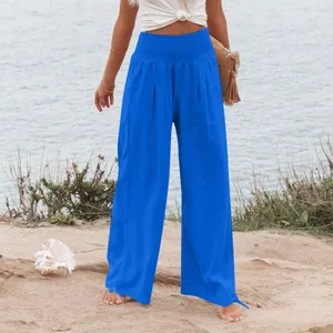 Vista dettagliata dei pantaloni larghi blu da donna con vita alta arricciata sulla spiaggia