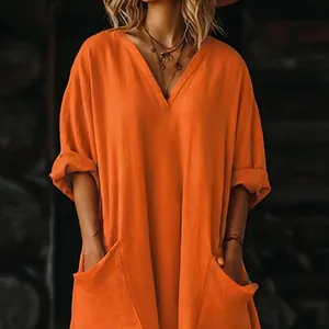 Vista detallada de vestido largo bohemio naranja con cuello en V y prácticos bolsillos