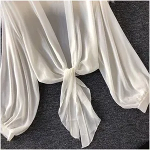 Close-up of white sheer chiffon sun protection blouse with tie-front knot and sleeves