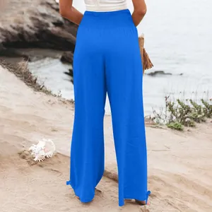 Vista posteriore di pantaloni casual blu a gamba larga con vita a nido d'ape sulla spiaggia