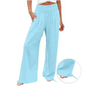 Dettaglio dei pantaloni larghi azzurri con vita a nido d'ape e coulisse sull'orlo.