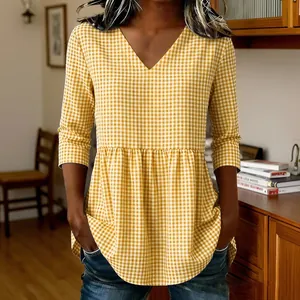 Detailed view of a women's yellow gingham V-neck peplum top with elegant 3/4 sleeves