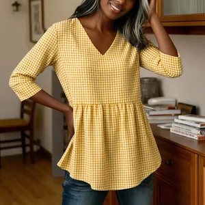 Close-up of a stylish yellow gingham V-neck top featuring a ruffled peplum hem design