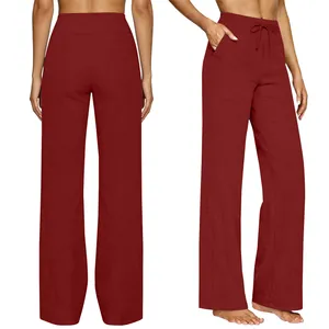 Detail view of high-waisted burgundy wide-leg pants with drawstring and pockets.