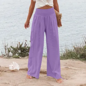 Vista dettagliata pantaloni viola a vita alta con fascia elastica arricciata in spiaggia.