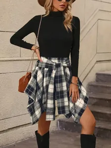 Detailed view of fashionable asymmetrical plaid tie-waist skirt on model.