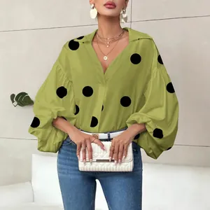 Detailed view of lime green blouse with black polka dots and puff sleeves