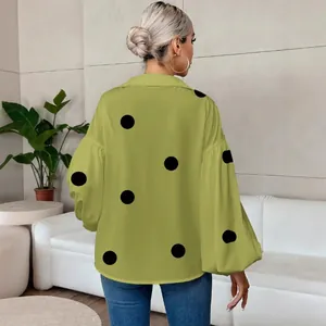 Back view of a lime green polka dot blouse featuring oversized long bubble sleeves