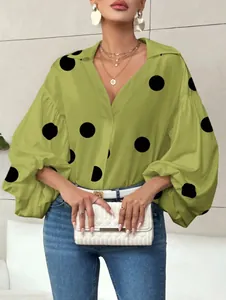 Detail of olive green polka dot blouse with puff sleeves and V-neckline styling