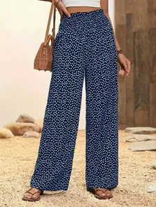 Gros plan d'un pantalon fluide à fleurs bleu marine à taille haute sur un modèle en extérieur