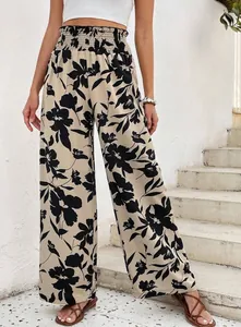 Détail de ce pantalon large à imprimé floral, taille haute avec une ceinture smockée.