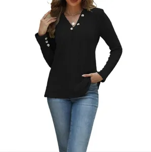 Detailweergave van zwart geribbeld shirt met lange mouwen, V-hals en knopen