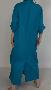 Back view of teal maxi dress with long sleeves and a stylish back slit detail.