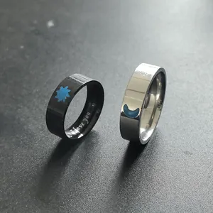 Close-up of luminous sun and moon stainless steel couple rings with I love you engraving