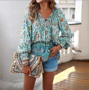 Detail of bohemian floral print V-neck blouse with tie and long smocked sleeves
