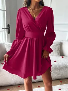 Vue détaillée d'une robe fuchsia à col en V avec taille cintrée et double épaisseur.