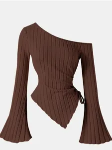 Detailed view of the brown ribbed knit fabric and asymmetrical flare sleeve design.