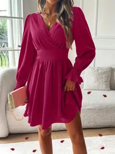 Détail d'une robe fuchsia à col en V avec des manches lanternes et un ourlet volanté