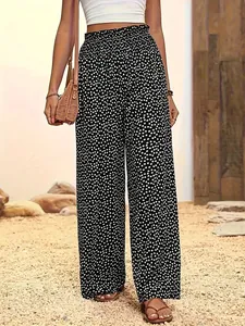 Détail du pantalon large noir à pois à taille haute avec une ceinture élastique