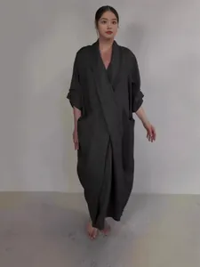 Elegant black V-neck maxi dress with large pockets in a relaxed bathrobe-style silhouette