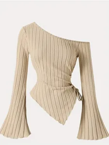 Detail view of ribbed one-shoulder top with flared sleeves and asymmetrical hemline