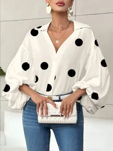 Macro detail of white long sleeve blouse featuring puff sleeves and large black polka dots