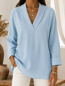 Close-up detail of a light blue shawl collar V-neck blouse featuring textured fabric