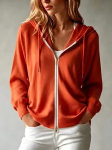 Primo piano di un cardigan in maglia arancione con cappuccio in stile francese casual.