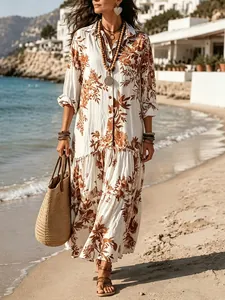 Full view of bohemian floral print maxi dress styled with a straw bag on the beach