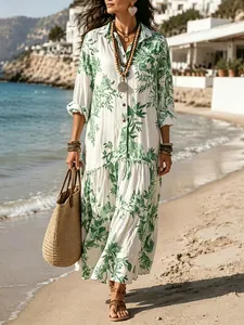 Elegant bohemian maxi shirt dress with green plant print and pleated hem on sunny beach