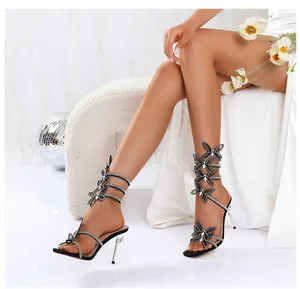 Detailansicht der Schmetterlings-Strass-Stilettos mit Schlangenwicklung an einem Modell