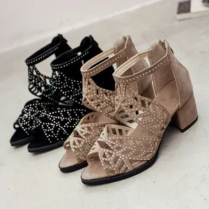 Macro view of stylish hollow peep-toe sandals with sparkling rhinestones and thick heels