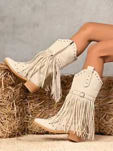Detail of beige western cowboy boots with fringe, rivets, and buckle on a model