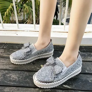 Chaussures compensées argentées élégantes avec nœud en strass étincelant pour femmes.
