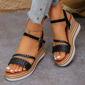 Close-up of stylish black braided wedge sandals featuring a gold platform and ankle strap buckle