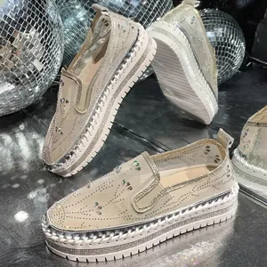 Detailed view of women's rhinestone platform loafers with a disco ball background.