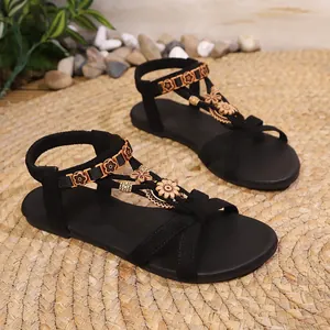 Sandali piatti boho neri con cinturino elastico e decorazioni floreali in legno