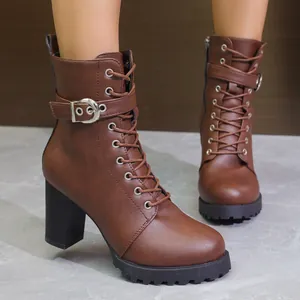 Gros plan sur ces bottines marron à talons épais avec lacets et bride à boucle élégante